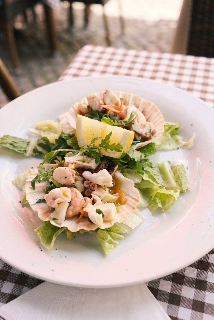 Meeresfrüchtesalat in der Jakobsmuschel serviert