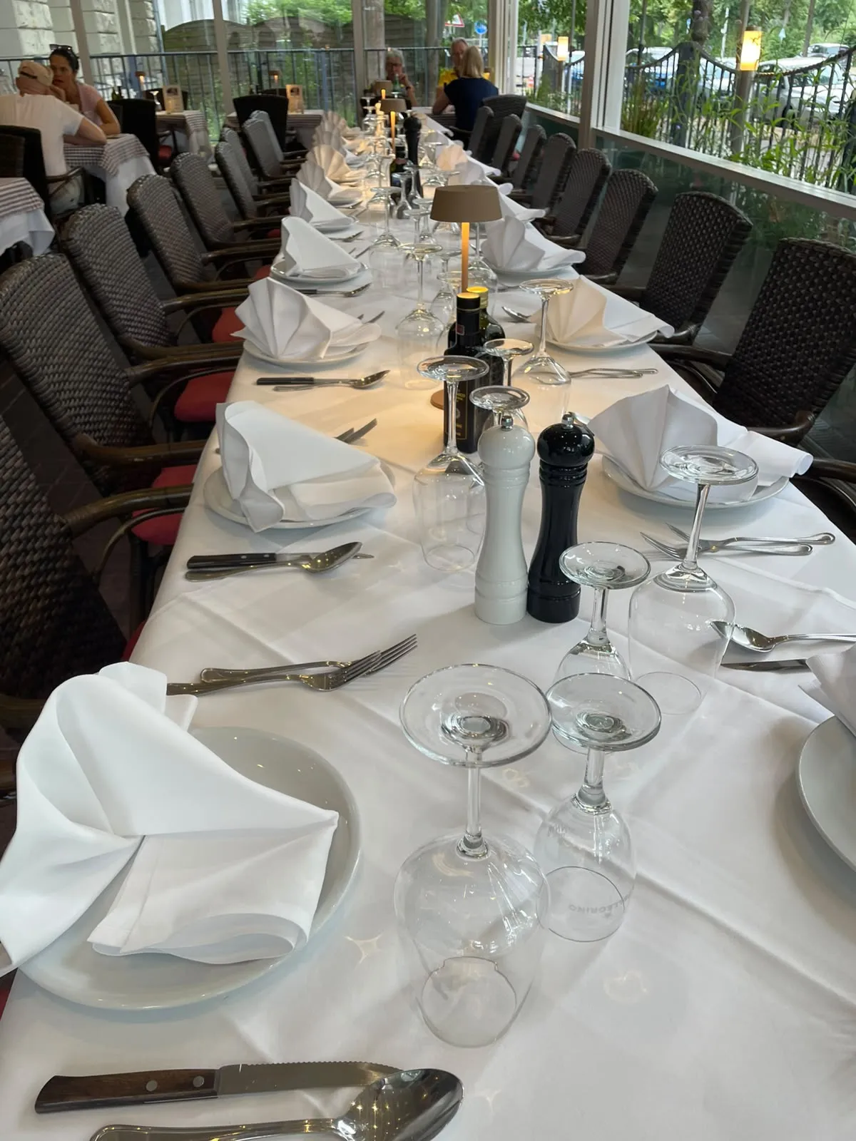 Festlich eingedeckte lange Tafel im Wintergarten