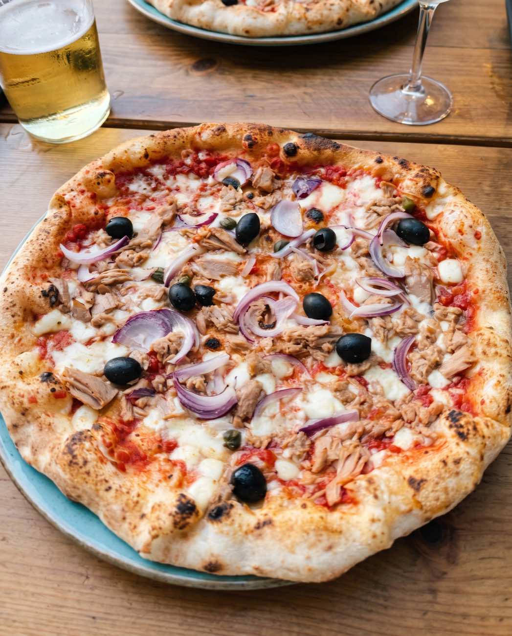 Steinofenpizza mit dünnem Boden, Thunfisch und Oliven